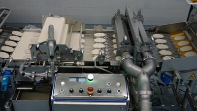 Das geführte Rückströmsystem des GEA ProCoater reduziert Lufteintrag und Schaumbildung um bis zu 80 Prozent. Das führt zu einem ruhigeren und gleichmäßigeren Fluss der Nasspanade. Quelle: GEA